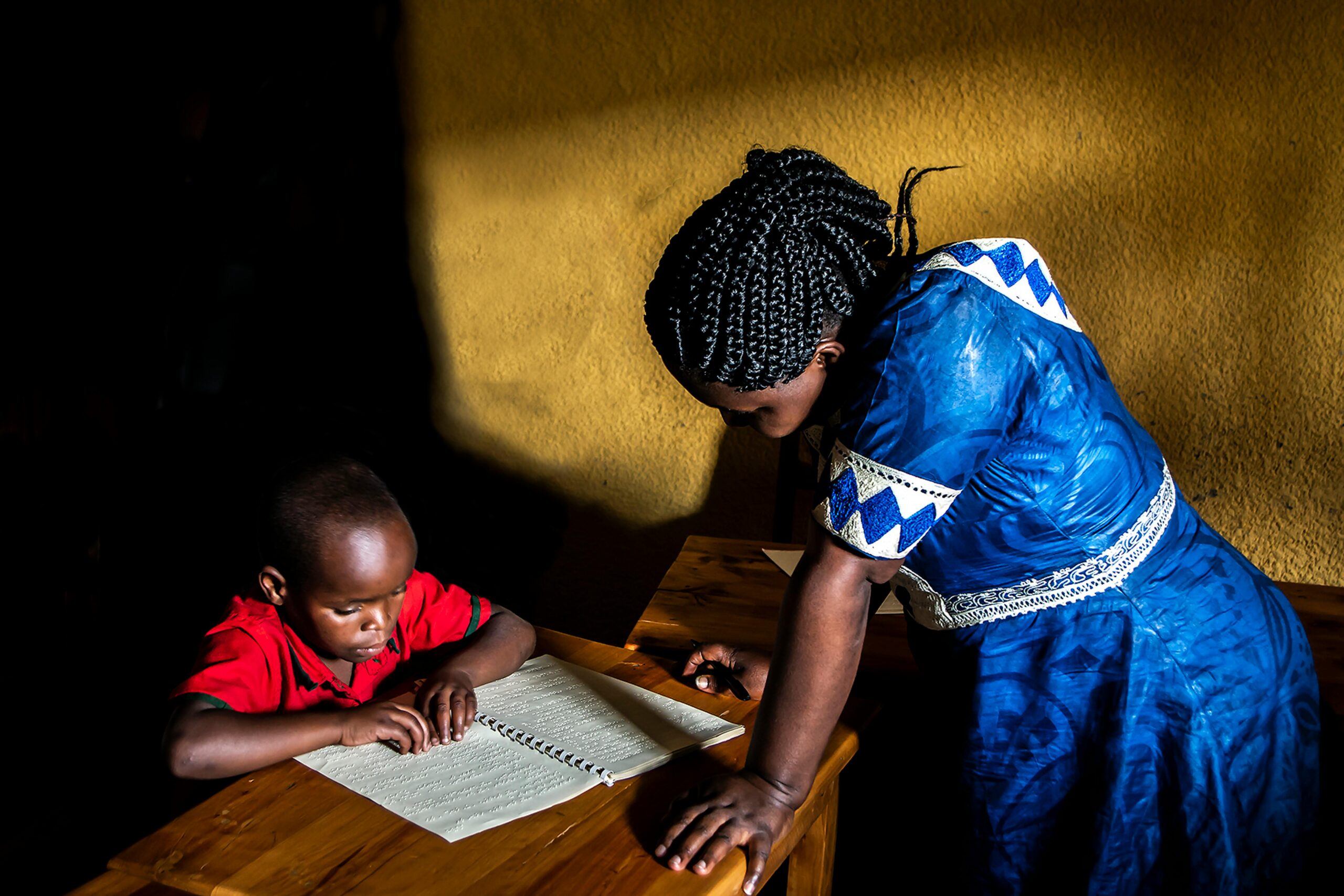 African student and teacher engage in braille reading. Northern Province, Rwanda.