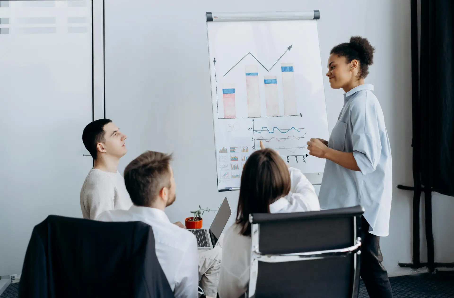 Multicultural team in office brainstorming business strategy with charts.