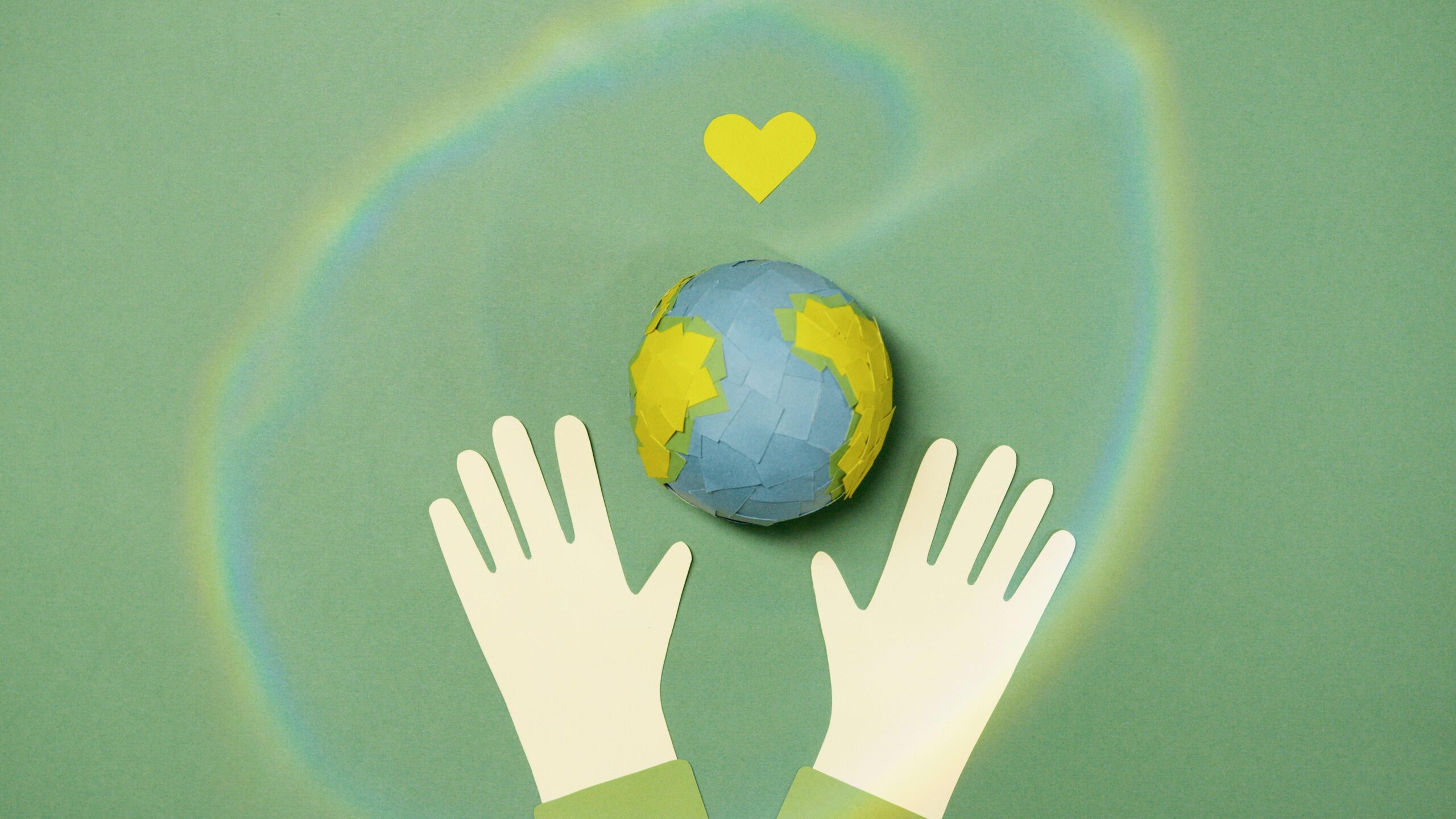 Illustration of hands with paper Earth and heart symbol representing environmental protection.