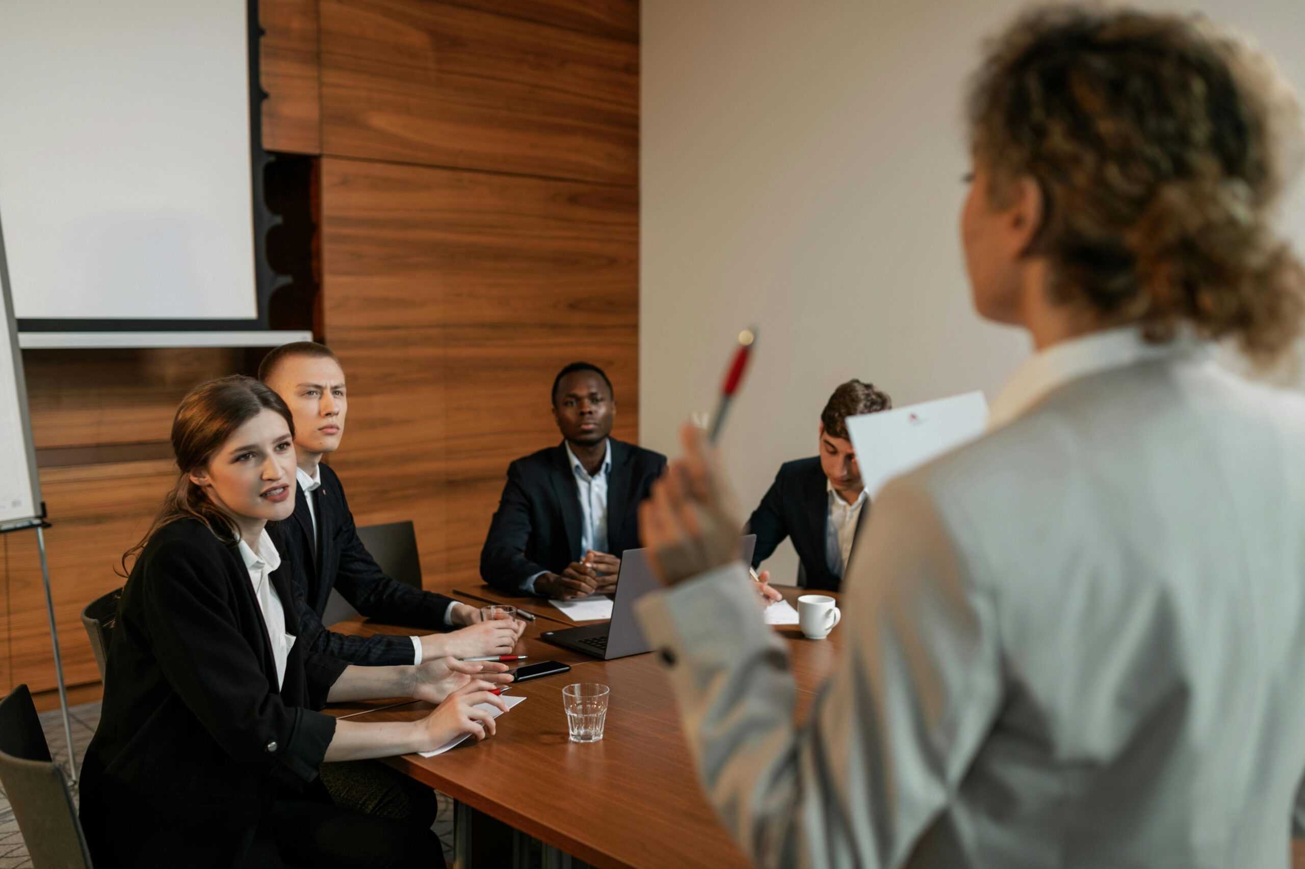Professional business discussion among diverse colleagues in a modern office setting.