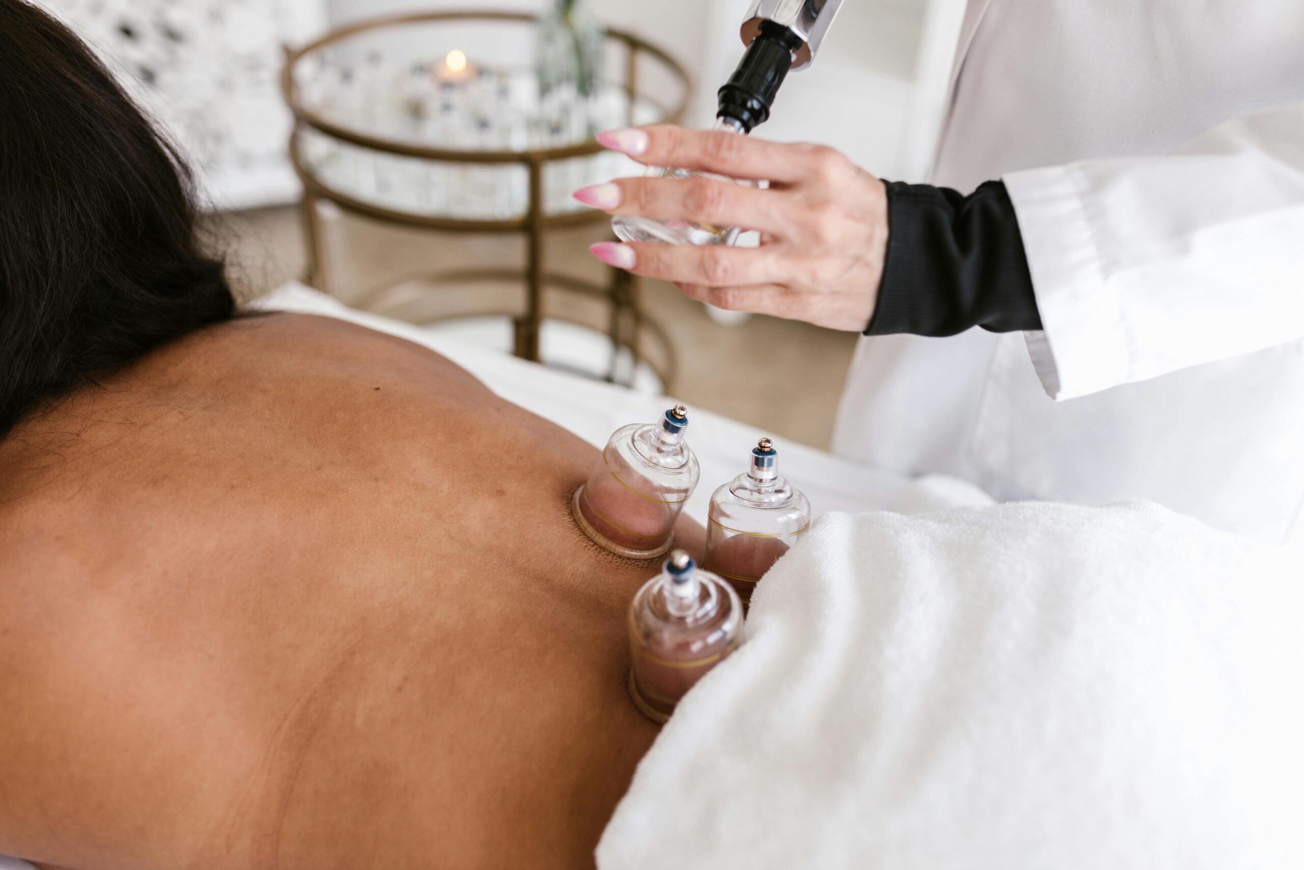 A woman receiving cupping therapy in a serene spa setting to relieve pain and stress.
