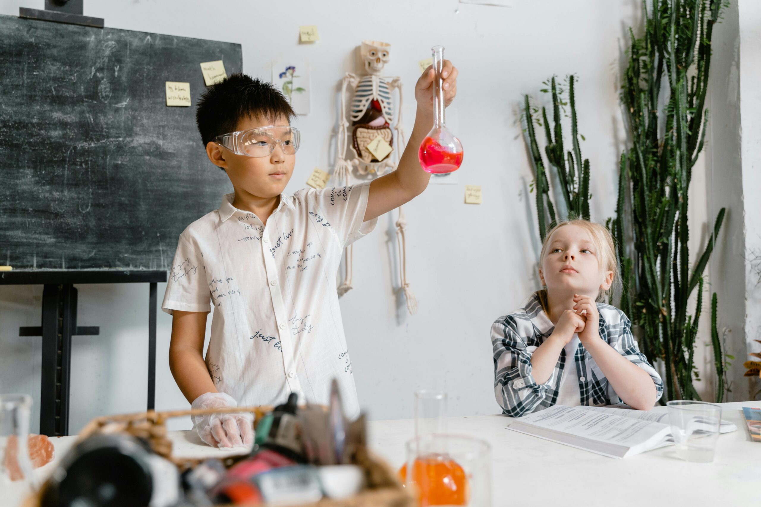 Two children experimenting with chemicals in a classroom, focusing on learning.